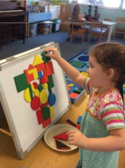Girl playing with a magnetic shapes board